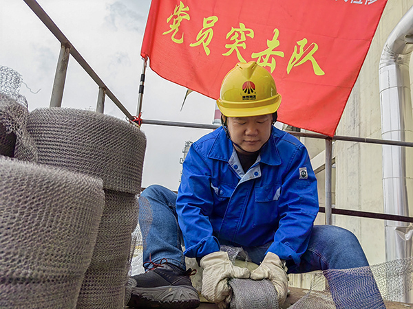 5月10日中午，在動力車間三期工藝除氧器平臺上，黨員突擊隊(duì)隊(duì)長李鑫正在纏繞新填料.jpg