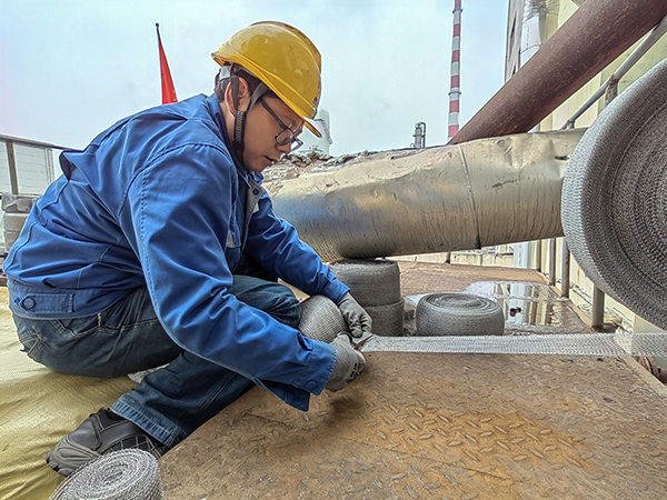 5月10日中午，在動力車間三期工藝除氧器平臺上，黨員突擊隊(duì)隊(duì)員劉瑞斌正在纏繞新填料.jpg