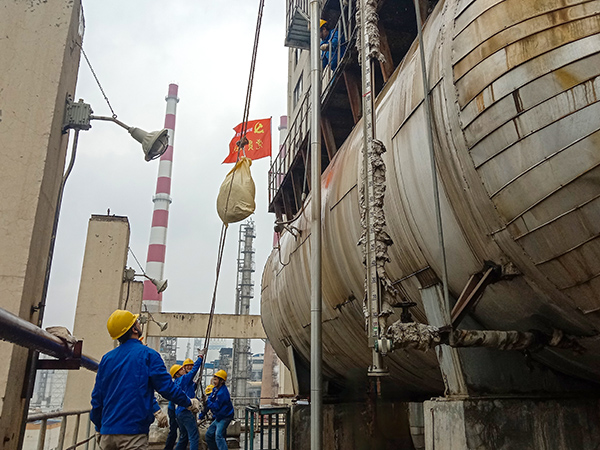 5月10日中午，在動力車間三期工藝除氧器地面，黨員突擊隊(duì)隊(duì)員用滑輪往工藝除氧器平臺運(yùn)送鋼絲網(wǎng)，用以纏繞新填料.jpg