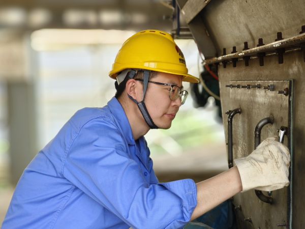 5月11日，尿素車間設(shè)備技術(shù)員馬強(qiáng)檢查設(shè)備螺栓是否松動(dòng).jpg